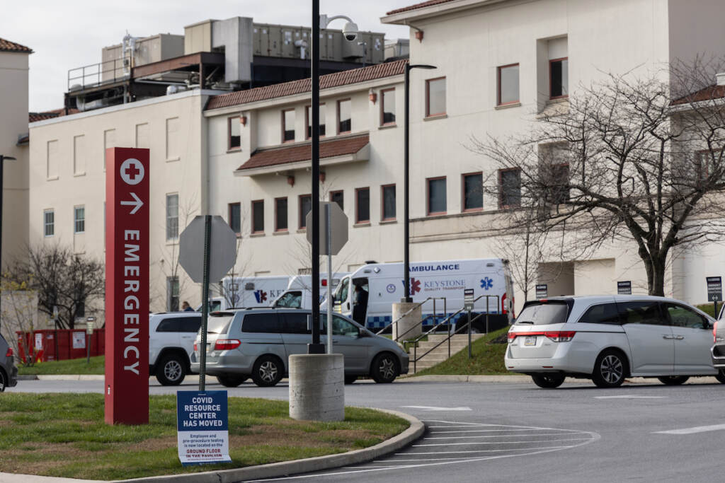 A view of a sign that reads emergency in a parking lot.