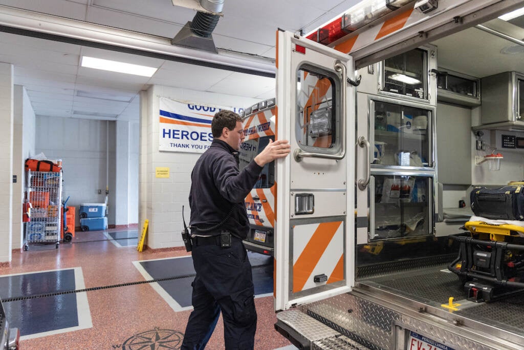 A man closes the door to an ambulance.