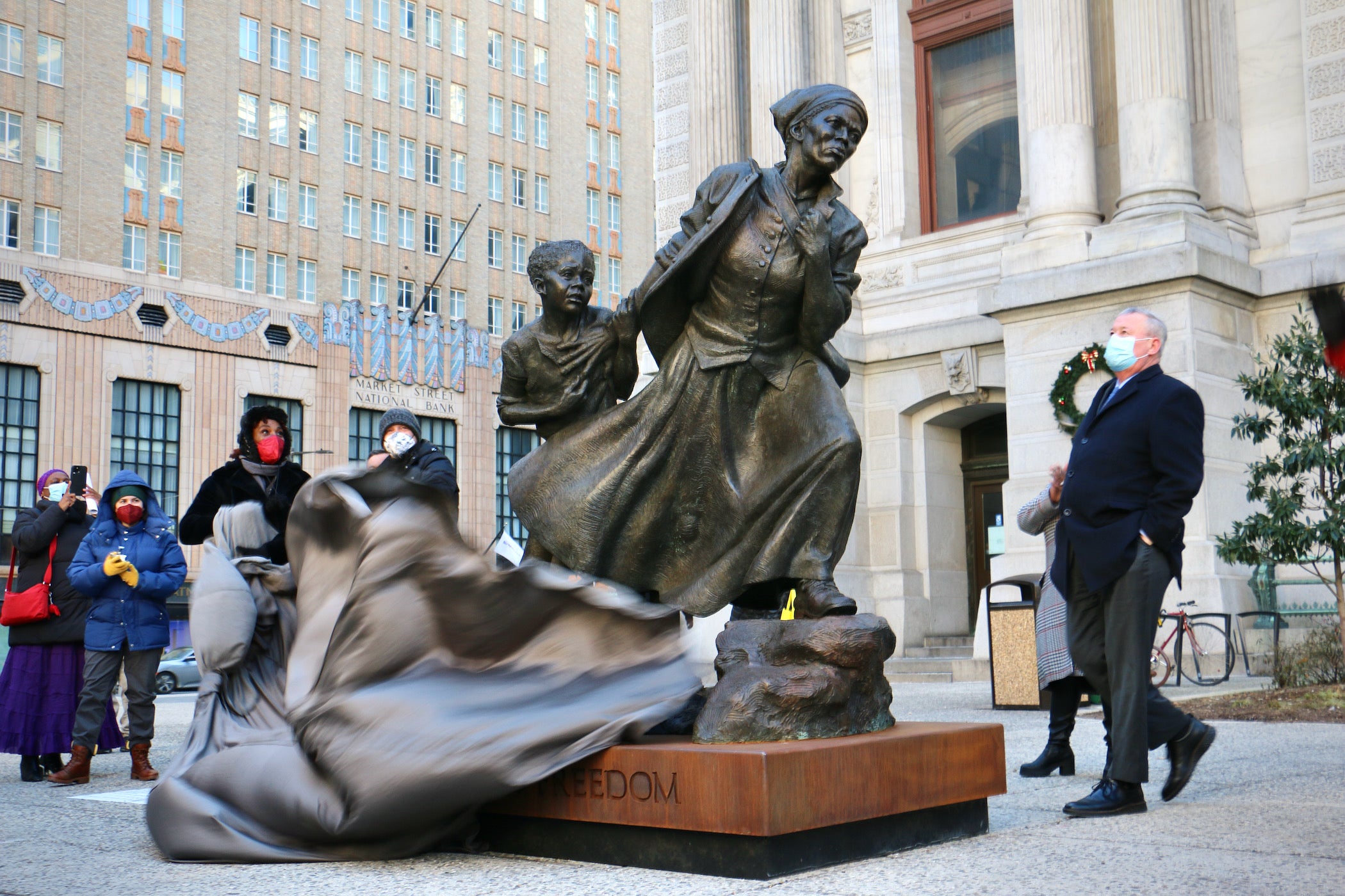 Philadelphia unveils a statue of Harriet Tubman on the North Apron of City Hall. Singer Valerie Gay (left) and sculptor Wesley Wofford remove the veil while Mayor Jim Kenney (right) looks on.