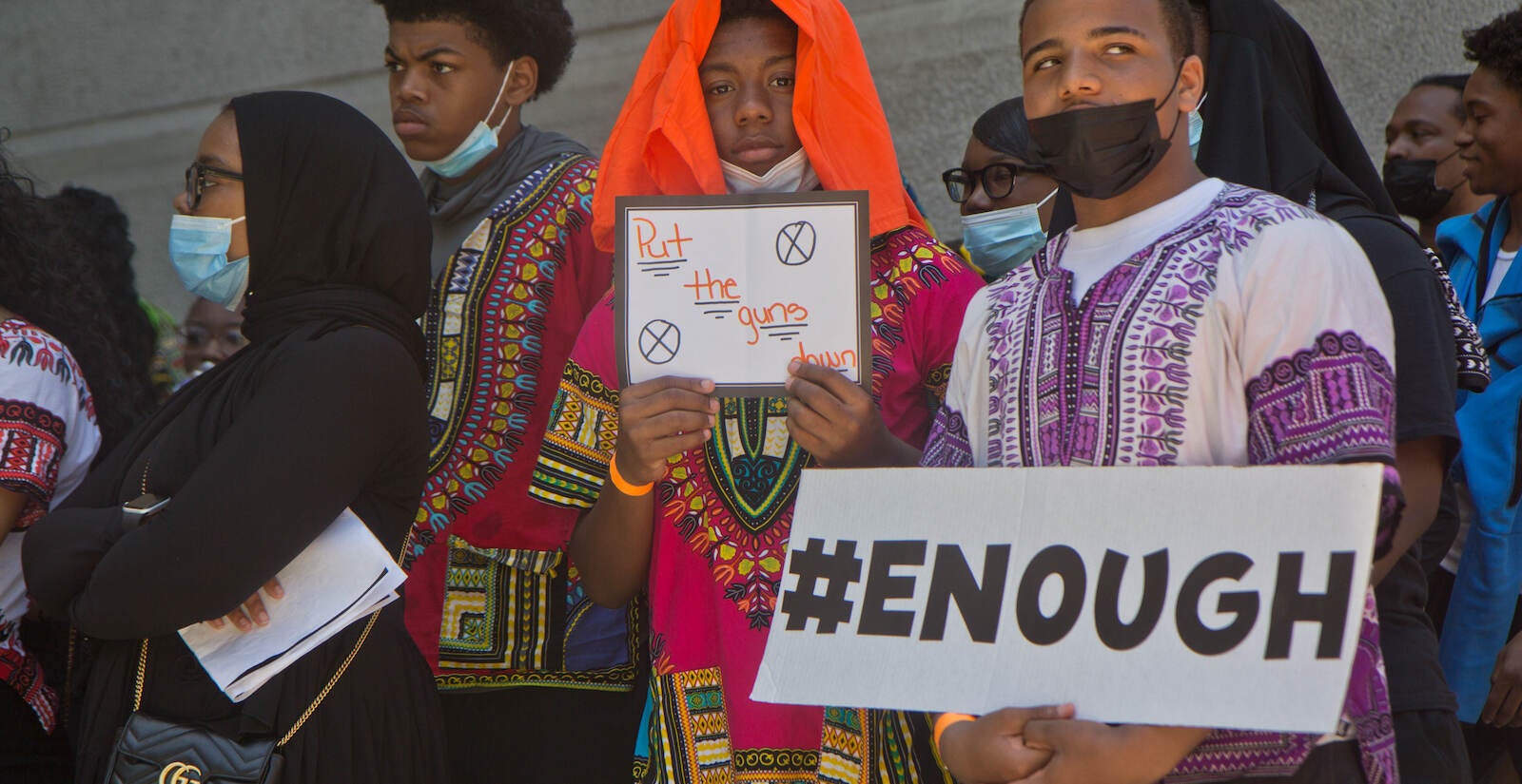 Students protesting against gun violence hold signs that say ''#Enough'' and ''Put the guns down.''