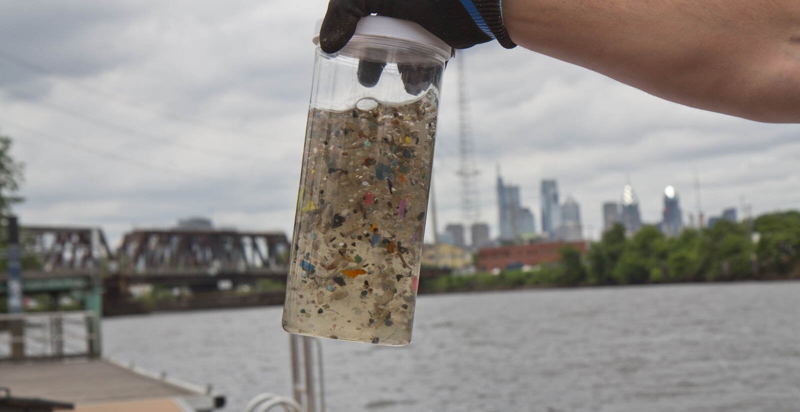 A hand holds up microplastics collected out of the Delaware River