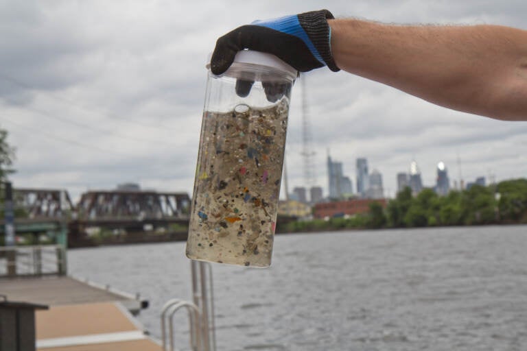 A hand holds up microplastics collected out of the Delaware River