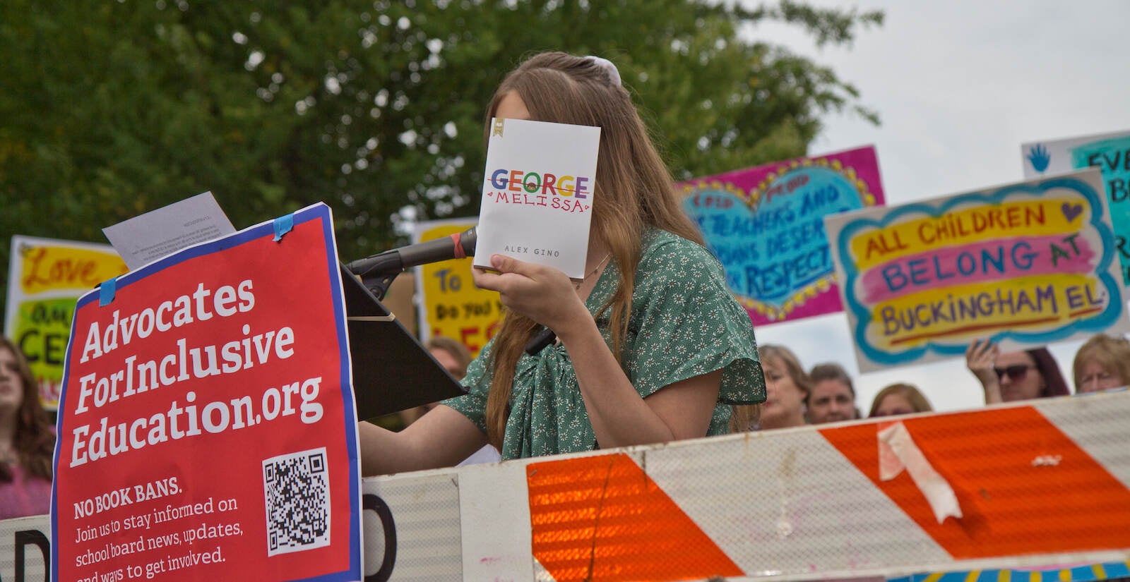 Lilly Freeman holds up a book at a protest at Central Bucks