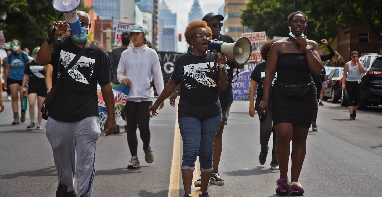 University City Townhomes residents Sheldon David (left), Darlene Forman (second from left), Rasheda Alexander (second from right) and Krystal Young march down a Philly street