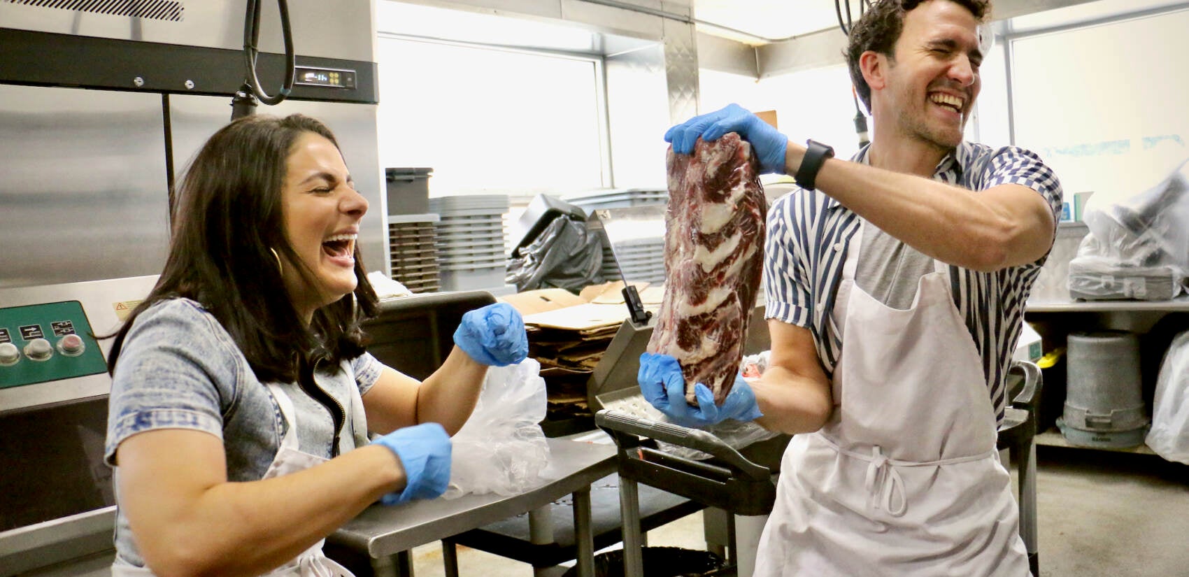 Gianna Yanelli (left), who portrays Adrian in Walnut Street Theatre’s production of ‘’Rocky, the Musical,’’ and Matthew Amira, who portrays Rocky, take turns punching a frozen ribeye