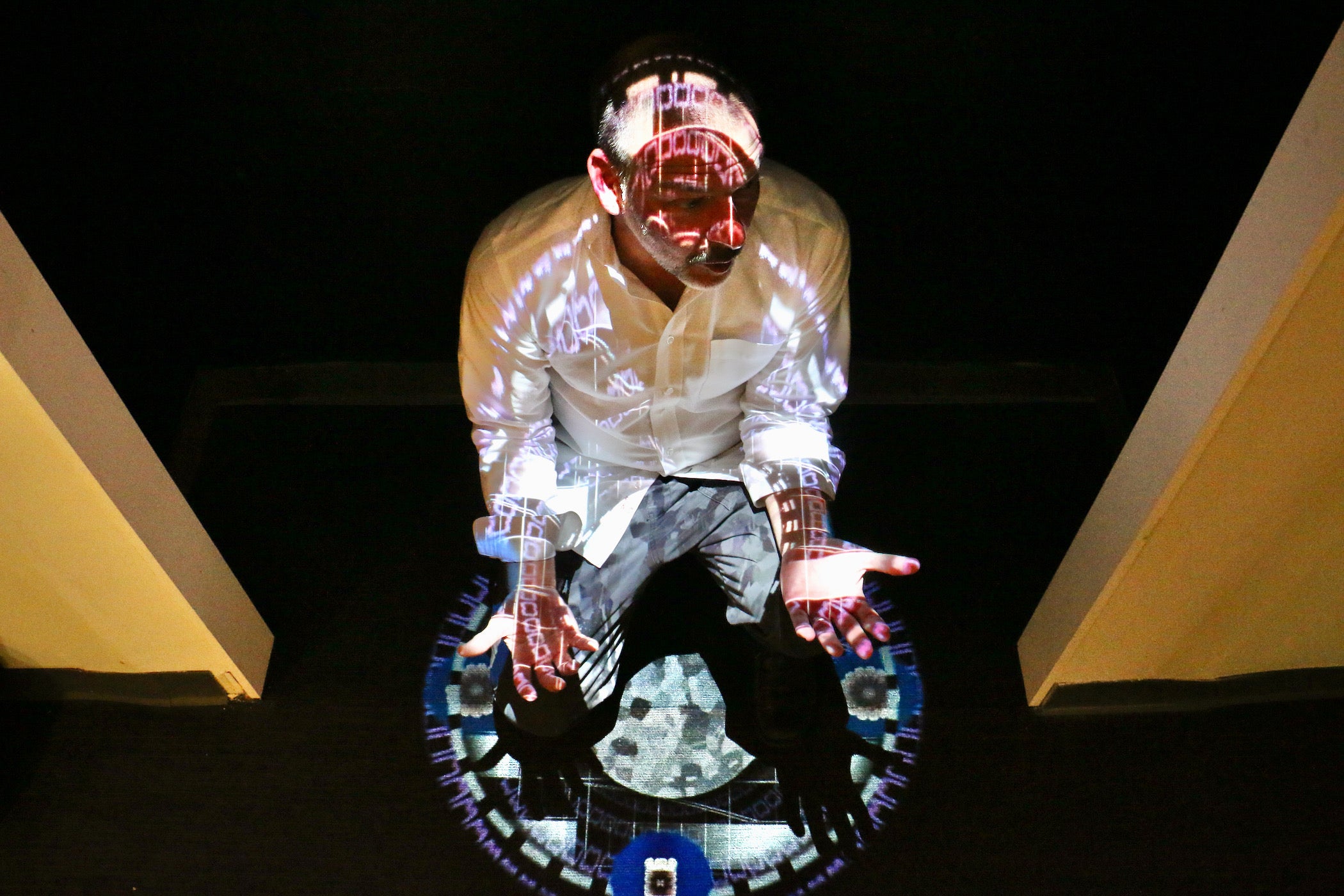 Joseph Lazaro Rodriguez crouches beneath his digital projection, ''Chromatherapeutics: Veritas DS,'' on display at the National Liberty Museum