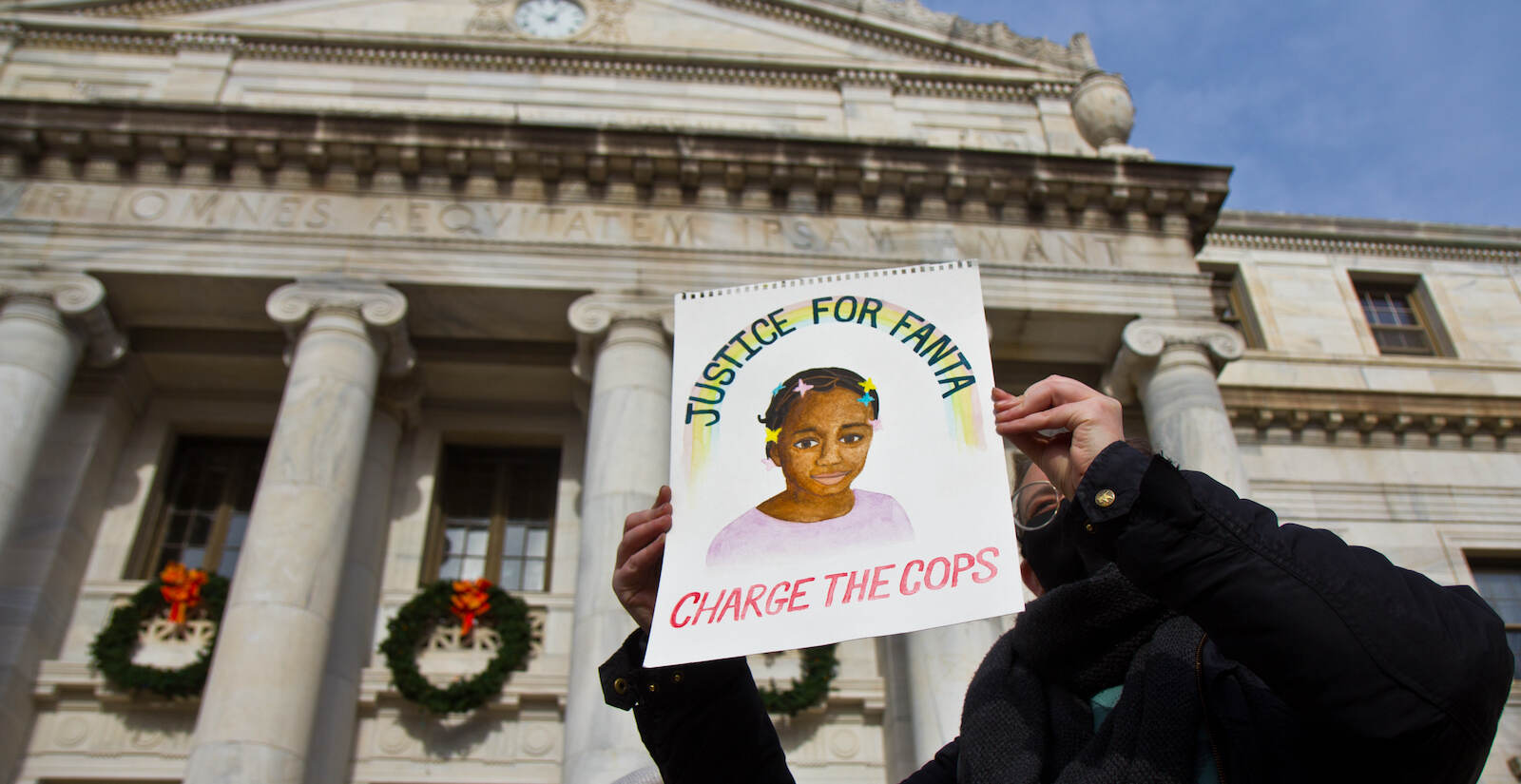 Robin Markle holds up a painting of Fanta Bility outside Delaware County Courthouse