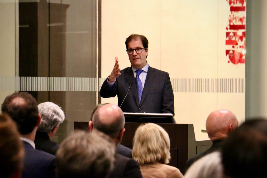 A man speaks at a podium.