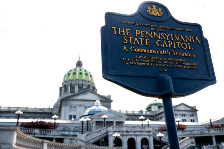 A sign is visible in front of the Pa. State Capitol building.