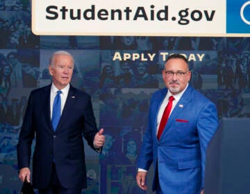 President Biden stands with Education Secretary Miguel Cardona