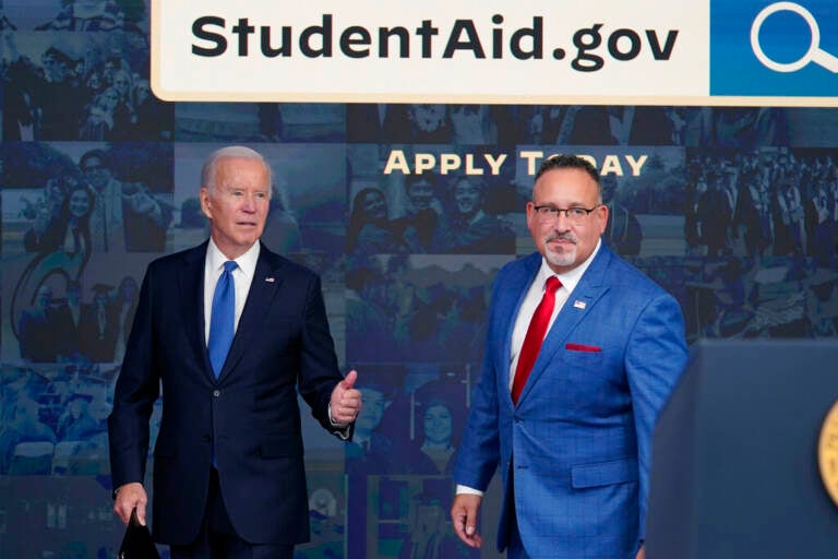 President Biden stands with Education Secretary Miguel Cardona