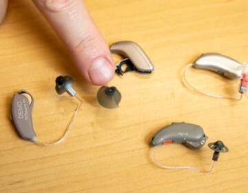 Sterling Sheffield, an assistant professor of Speech, Language, and Hearing Sciences at the University of Florida, shows over-the-counter hearing aids Wednesday, Nov. 30, 2022, in Gainesville, Fla. (AP Photo/Alan Youngblood)