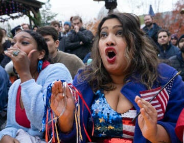 Fans of the United States soccer team Eesha Pendharkar, right, and Dania Abdalla react as they watch on television at a bar in Washington the United States team play against the Netherlands during their World Cup soccer match, Saturday, Dec. 3, 2022. (AP Photo/Manuel Balce Ceneta)