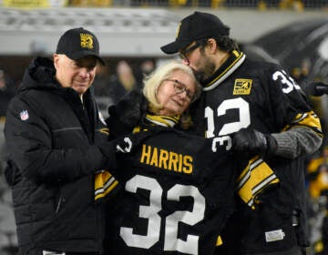 Pittsburgh Steelers owner Art Rooney II, left, and Franco Harris' widow Dana, center, and son Dok, attend a ceremony to retire Harris' No. 32 jersey at half-time of an NFL football game against the Las Vegas Raiders, Saturday, Dec. 24, 2022. Harris, a four-time Super Bowl champion, passed away Dec. 21, 2022, at the age of 72. (AP Photo/Don Wright)