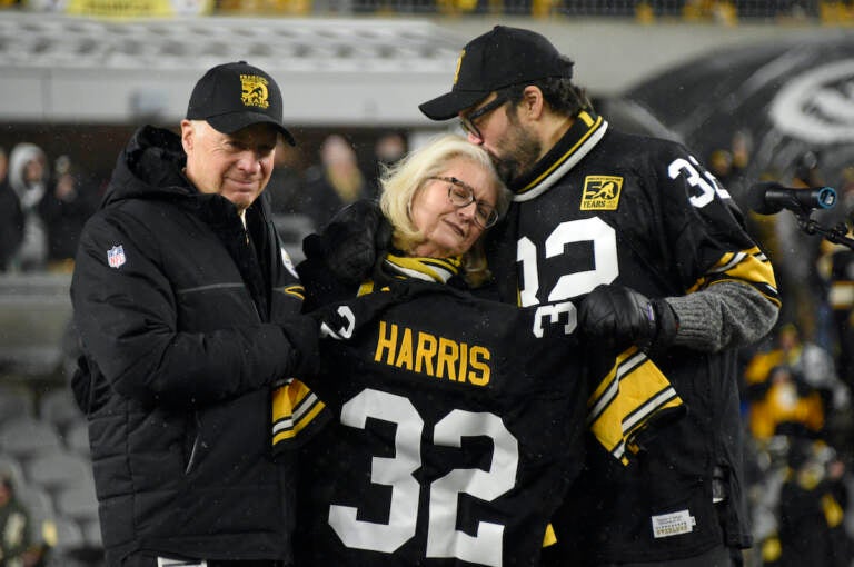 Pittsburgh Steelers owner Art Rooney II, left, and Franco Harris' widow Dana, center, and son Dok, attend a ceremony to retire Harris' No. 32 jersey at half-time of an NFL football game against the Las Vegas Raiders, Saturday, Dec. 24, 2022. Harris, a four-time Super Bowl champion, passed away Dec. 21, 2022, at the age of 72. (AP Photo/Don Wright)