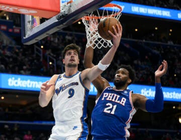 Washington Wizards forward Deni Avdija (9) goes to the basket against Philadelphia 76ers center Joel Embiid (21) during the first half of an NBA basketball game, Tuesday, Dec. 27, 2022, in Washington. (AP Photo/Nick Wass)