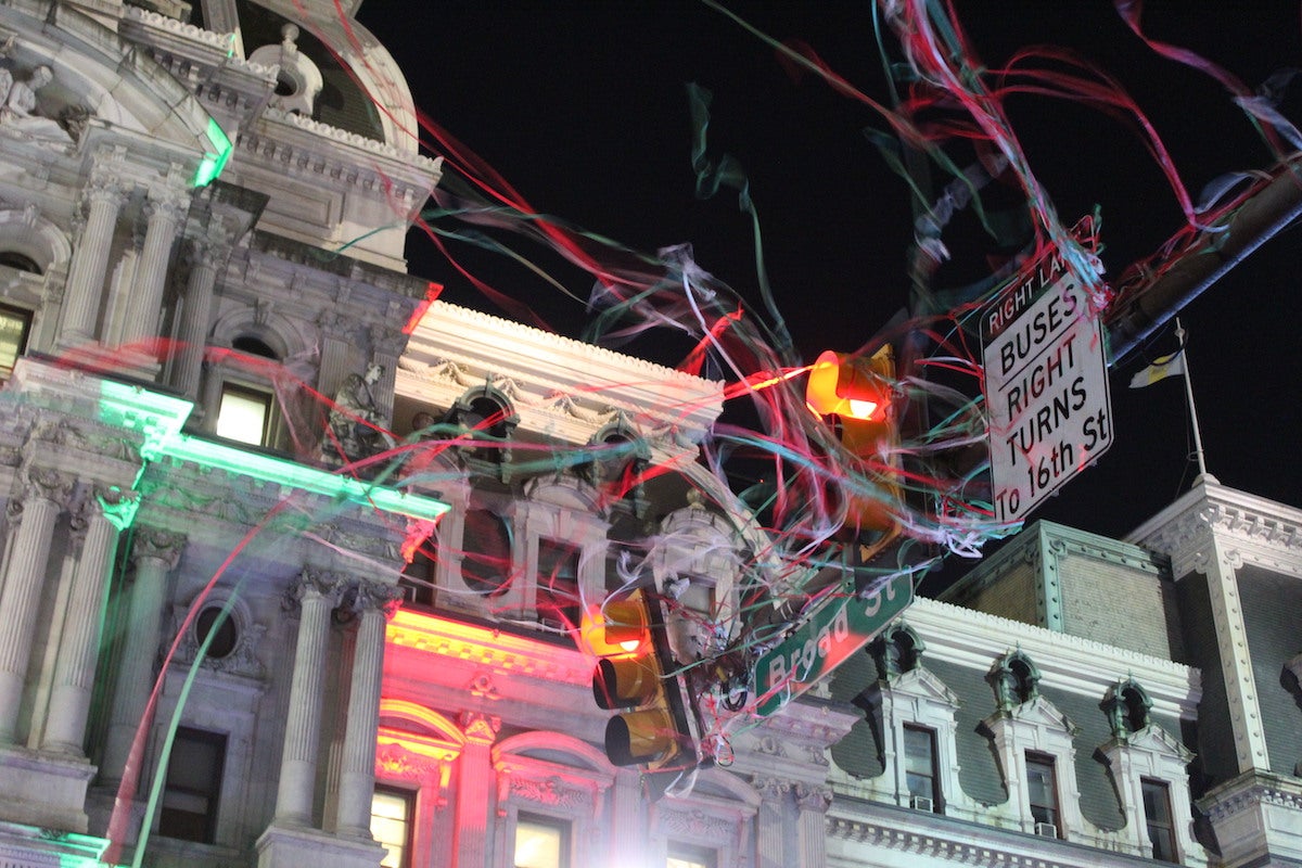 Confetti from the tree lighting got tangled up on a street light on Broad St. (Cory Sharber/WHYY)