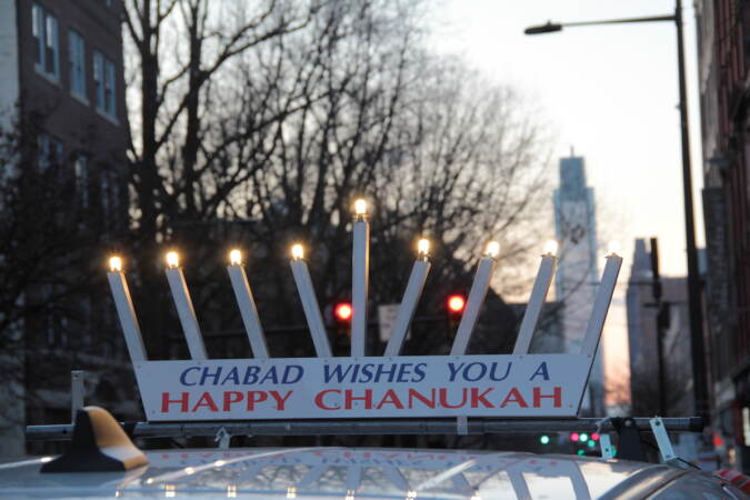 More than 150 people packed the sidewalk outside of the Betsy Ross House in Old City for a Menorah lighting on Dec. 18, 2022. (Cory Sharber/WHYY)