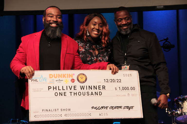 Gospel winner Frantastic Noise (center) received the check for $1,000 during Tuesday's PHL LIVE Center Stage Award Show. (Cory Sharber/WHYY)