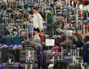 A woman walks through unclaimed bags at Southwest Airlines baggage claim at Salt Lake City International Airport on Thursday, as the carrier canceled another 2,350 flights after a winter storm overwhelmed its operations days ago. (Rick Bowmer/AP)