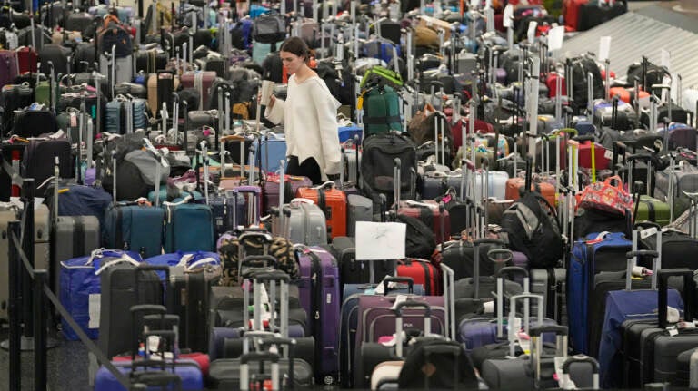 A woman walks through unclaimed bags at Southwest Airlines baggage claim at Salt Lake City International Airport on Thursday, as the carrier canceled another 2,350 flights after a winter storm overwhelmed its operations days ago. (Rick Bowmer/AP)