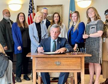 Governor John Carney, along with other government leaders and members of the Jewish community, sign the proclamation as part of the 'Shine a Light' campaign. (Johnny Perez-Gonzalez/WHYY)