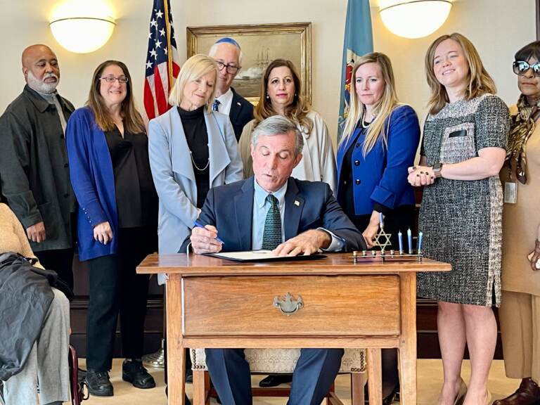 Governor John Carney, along with other government leaders and members of the Jewish community, sign the proclamation as part of the 'Shine a Light' campaign. (Johnny Perez-Gonzalez/WHYY)