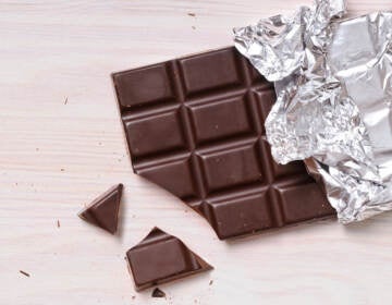 An unwrapped chocolate bar is shown, partially eaten.