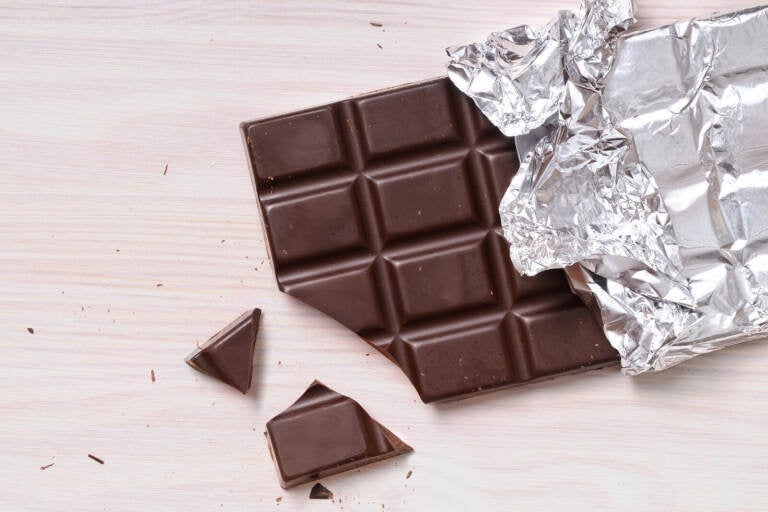 An unwrapped chocolate bar is shown, partially eaten.