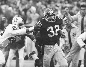 Franco Harris (32) eludes a tackle by Oakland Raiders' Jimmy Warren as he runs 42-yards for a touchdown after catching a deflected pass during an AFC Divisional NFL football playoff game in 1972