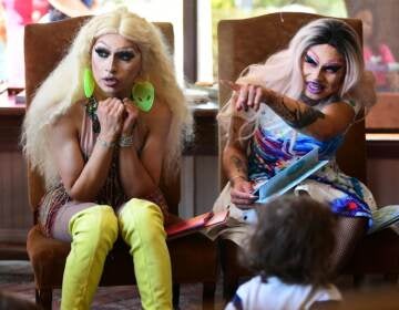 Athena Kills (left) and Scalene Onixxx are pictured during Drag Queen Story Hour in Riverside, Calif. The rise of family-friendly drag events has sparked a backlash among right-wing media and organizers. (Frederic J. Brown/AFP via Getty Images)