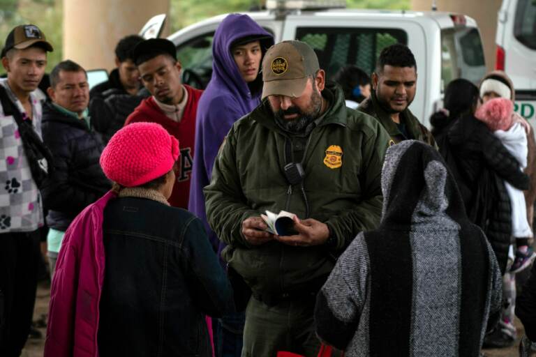  Border Patrol agent checks an asylum seeker's passport after she turned herself in, in Eagle Pass, Texas, on Dec. 19. (Veronica G. Cardenas/AFP via Getty Images)