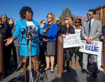 Rep. McClinton speaks at a podium surrounded by other people.