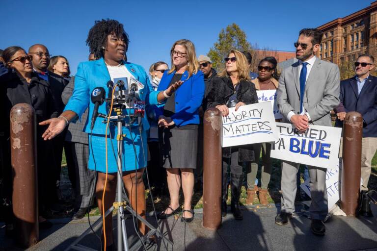 Rep. McClinton speaks at a podium surrounded by other people.