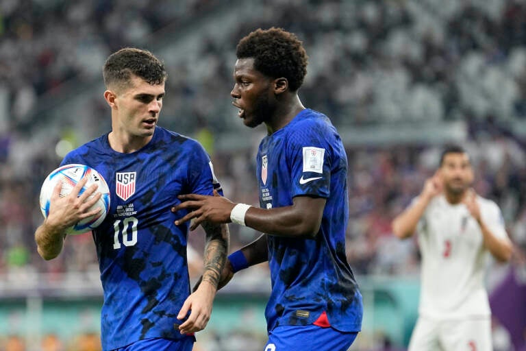 Christian Pulisic of the United States, left, and Yunus Musah of the United States speak before a free kick during the World Cup group B soccer match between Iran and the United States at the Al Thumama Stadium in Doha, Qatar, Tuesday, Nov. 29, 2022. (AP Photo/Ebrahim Noroozi)