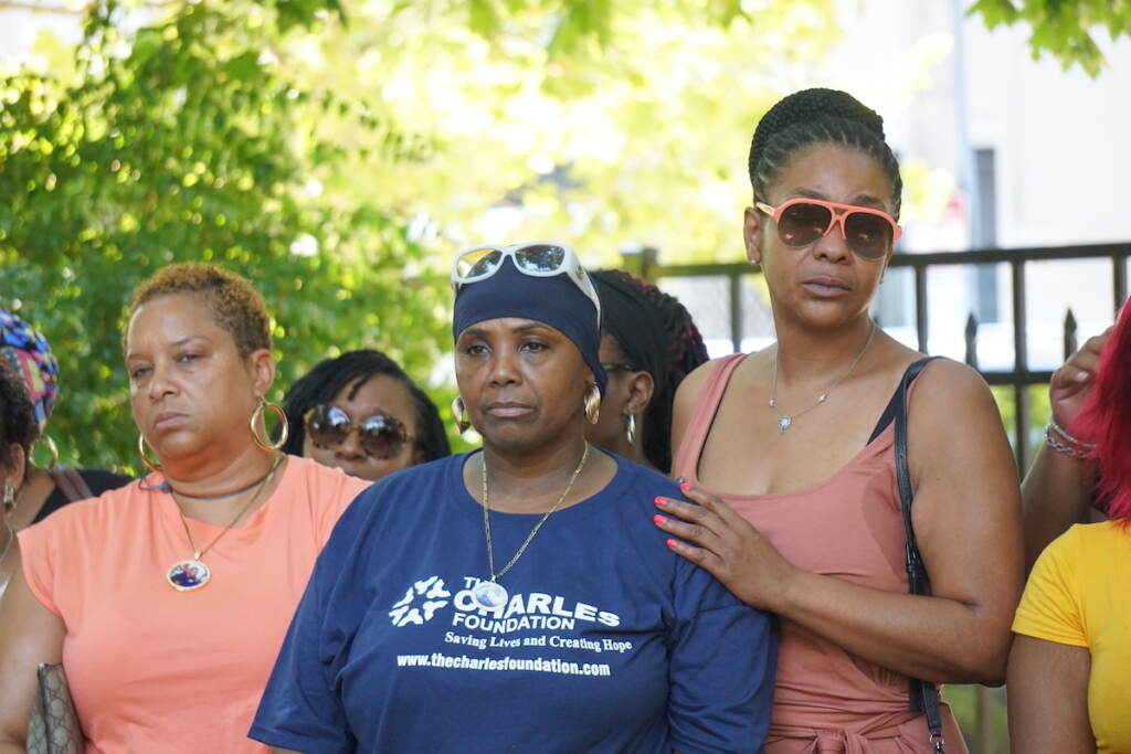 Women gather together and look towards the camera.