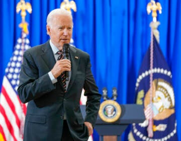 President Joe Biden speaks into a microphone.