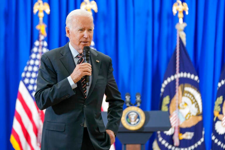 President Joe Biden speaks into a microphone.