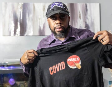 George Mink Jr. shows his COVID Reset t-shirt at his home in Delaware County, Pa