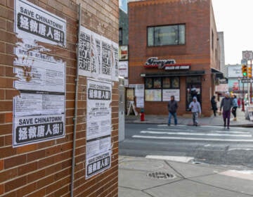 Posters at 10th and Arch Streets decry the development of a basketball arena in Philadelphia’s Chinatown neighborhood. (Kimberly Paynter/WHYY)