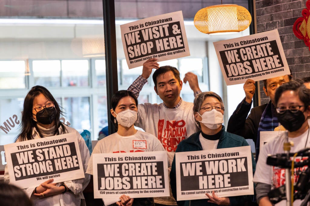 People hold signs saying "we work here" and "we create jobs here."