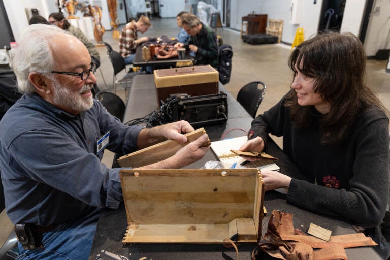 A volunteer (left) helps Leigh Hilford fix a sewing machine