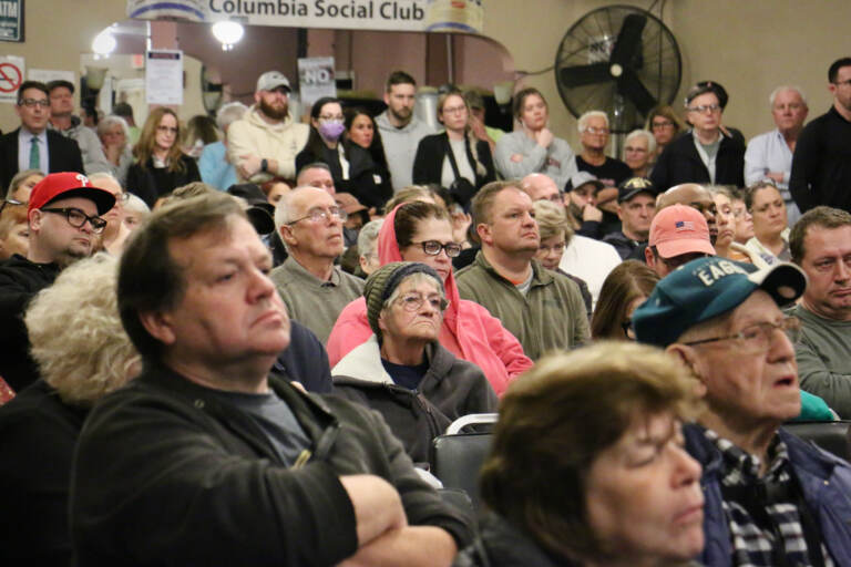 Port Richmond residents crowd into the Columbia Social Club looking for answers about the New Year's Day explosion that destroyed three homes on Miller Street. (Emma Lee/WHYY)