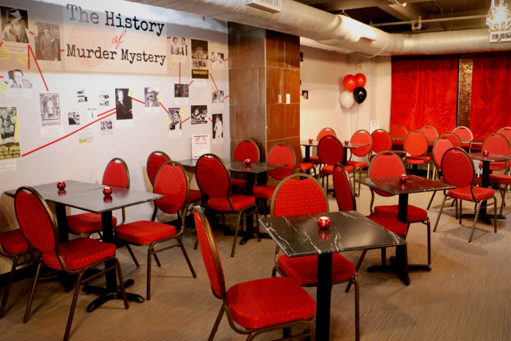 Empty tables and chairs are arranged in a room.