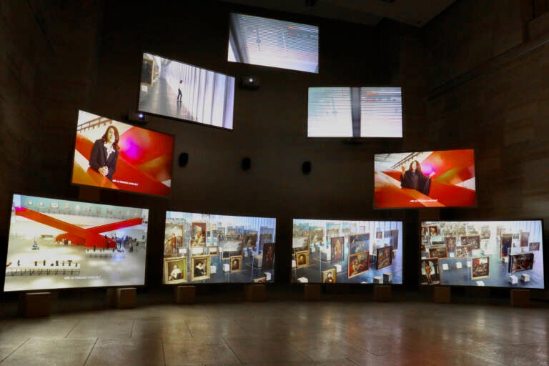 A row of screens are displayed in a gallery.