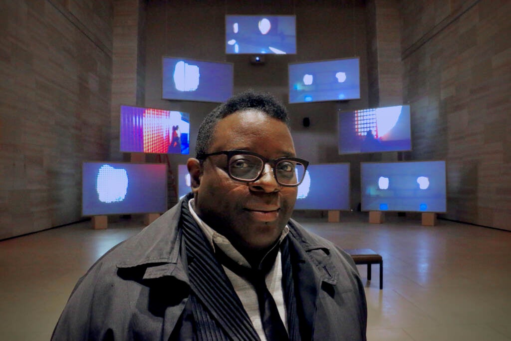 Isaac Julien stands in front of his installation art.