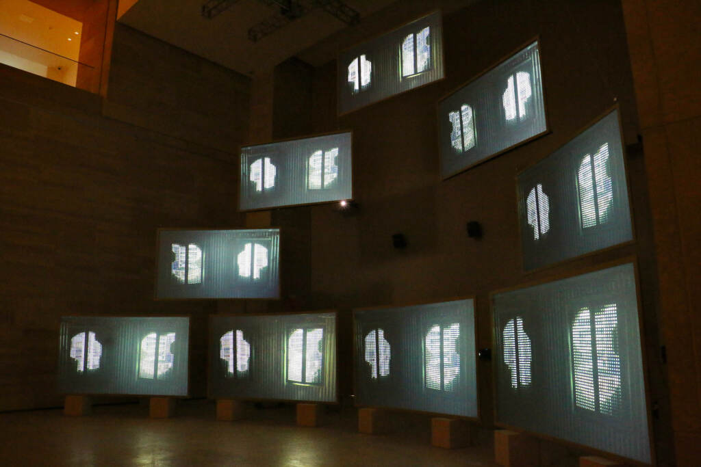 A row of screens are displayed in a gallery.