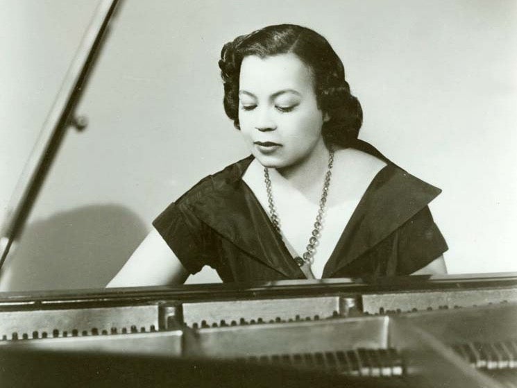 Margaret Bond seated at the piano in a black-and-white photograph.