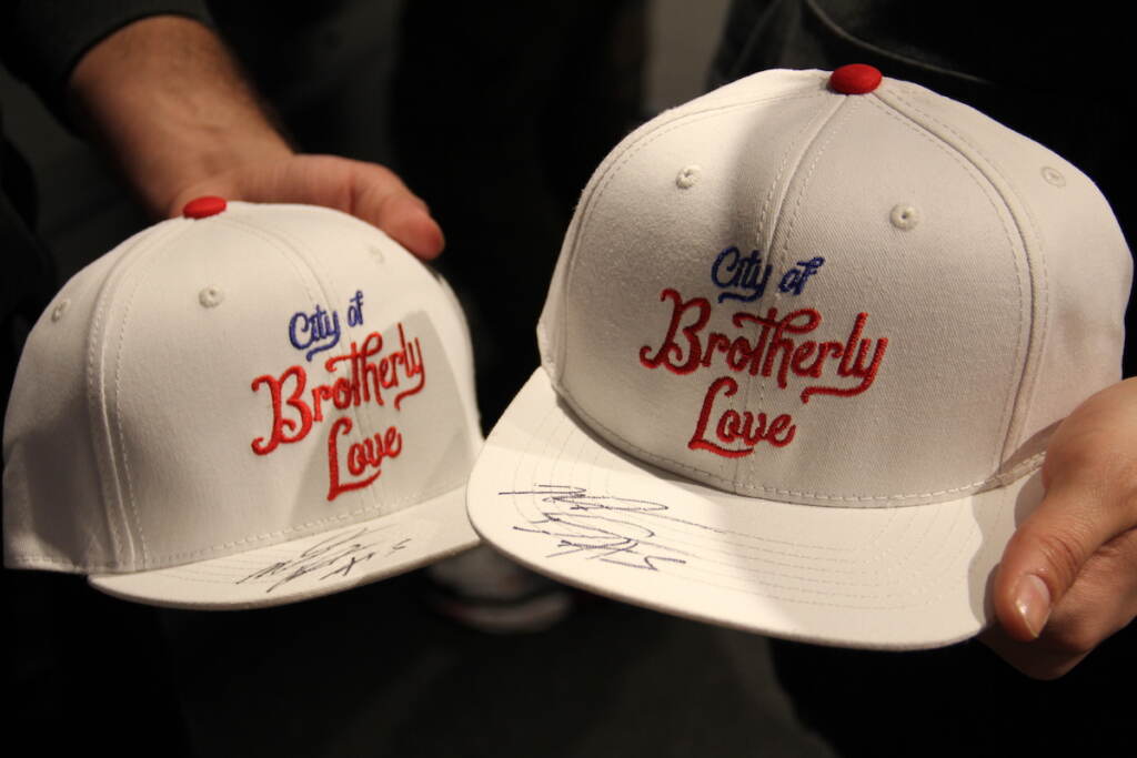 An upclose photo of two white baseball hats emblazoned with the words "City of Brotherly Love."