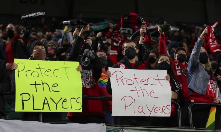 Portland Thorns fans hold signs during the first half of the team's National Women's Soccer League soccer match against the Houston Dash in Portland, Ore., Oct. 6, 2021